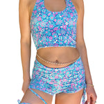 Person wearing a blue floral two-piece swimsuit indoors.